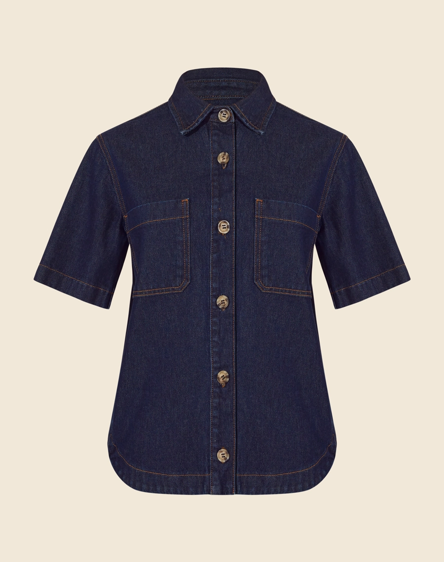 Camisa Bonnie confeccionada em jeans com lavagem escura. <br/>
Possui modelagem ampla e confortável, com mangas curtas e dois bolsos frontais que agregam praticidade. <br/>
O fechamento é frontal por botões de casa, trazendo um toque clássico e atemporal ao look. <br/>
Versátil, pode ser usada aberta como sobreposição ou fechada, compondo combinações modernas e despojadas.<br/>