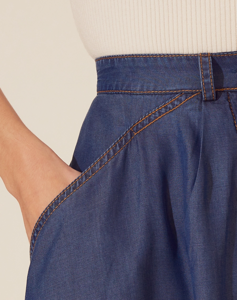 Saia Midi Malva confeccionada em Jeans possui modelagem evasê (ampla), cintura alta e dois bolsos laterais estilo faca.<br/>
Seu fechamento é frontal por botão de casa.<br/>
