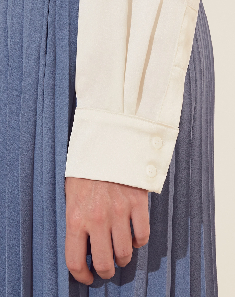 Camisa Gia confeccionada em  Valentino Stresh. <br/>
Sua gola é estilo smoking, com mangas longas e botão de casa nos punhos. <br/>
Modelagem ampla. 