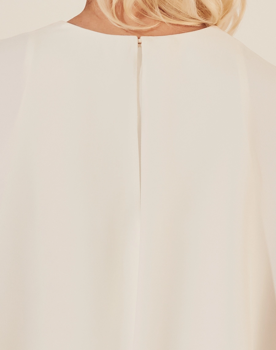 Vestido Midi Elia confeccionado em Crepe Patou. <br/>
Com gola redonda, fechamento por botão de aselha e ziper invisível nas costas.<br/>
Sua saia possuí detalhe de recorte com caimento assimétrico. <br/>