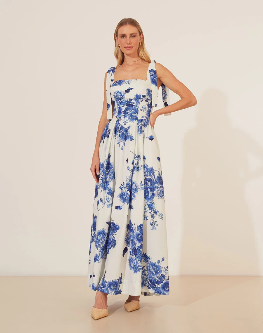 Vestido Longo Griselda é confeccionado em tricoline, um tecido de algodão conhecido por sua leveza e toque macio.<br/>
A peça apresenta uma estampa floral marcante que adiciona um charme especial ao look, perfeita para dias ensolarados ou eventos ao ar livre.<br/>
Seu decote quadrado com alças ajustáveis garante um ajuste confortável e feminino. <br/>
Com uma modelagem fluida e comprimento longo, é uma opção versátil que pode ser usada tanto em momentos casuais quanto mais formais.<br/>