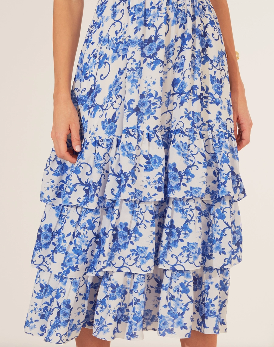 Vestido Midi Le Lautin é a escolha perfeita para quem busca um toque de sofisticação com delicadeza. <br/>
Confeccionado em crepinho leve, o vestido exibe uma estampa floral azul que remete à elegância da porcelana clássica. Com decote em coração, alças largas e detalhes de amarração no busto, ele destaca a feminilidade com charme. <br/>
A saia em camadas fluídas proporciona movimento e leveza, ideal para ocasiões que pedem um look refinado e confortável.<br/>