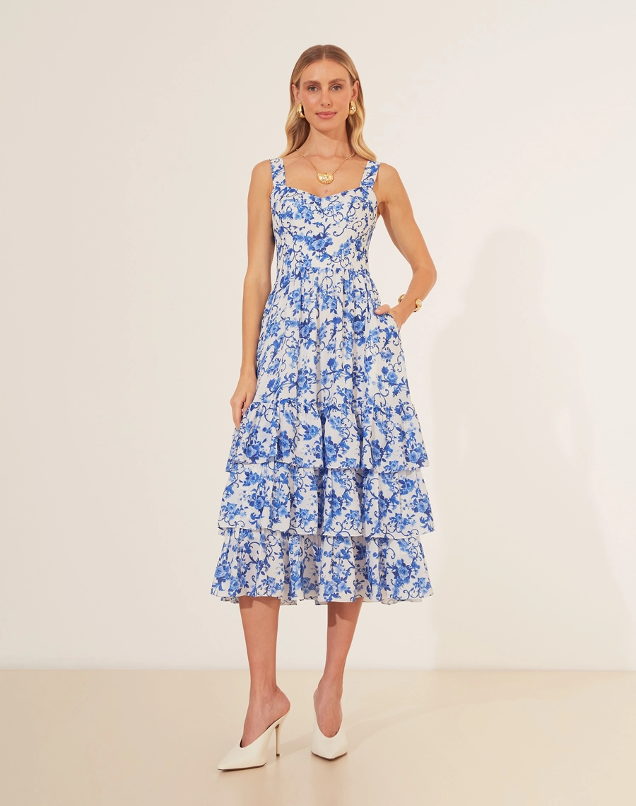 Vestido Midi Le Lautin é a escolha perfeita para quem busca um toque de sofisticação com delicadeza. <br/>
Confeccionado em crepinho leve, o vestido exibe uma estampa floral azul que remete à elegância da porcelana clássica. Com decote em coração, alças largas e detalhes de amarração no busto, ele destaca a feminilidade com charme. <br/>
A saia em camadas fluídas proporciona movimento e leveza, ideal para ocasiões que pedem um look refinado e confortável.<br/>