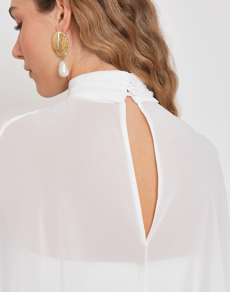 Capa Grazy é confeccionada em chiffon, um tecido leve e esvoaçante, que oferece um toque de sofisticação e delicadeza.