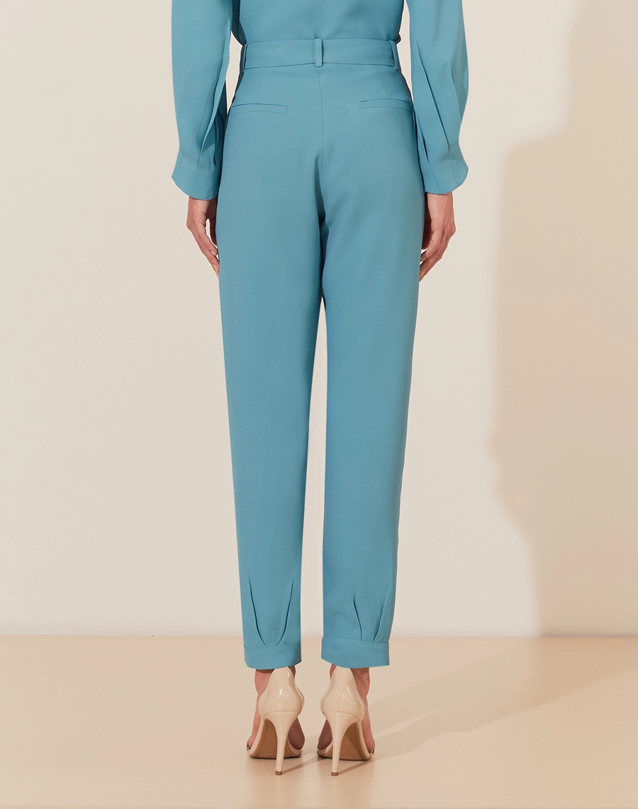 A Calça Vitória é confeccionada em crepe patou. Indispensável para quem busca um visual elegante e versátil, a Calça Vitória é perfeita para transitar facilmente entre reuniões de trabalho e eventos sociais, tanto de dia quanto à noite.