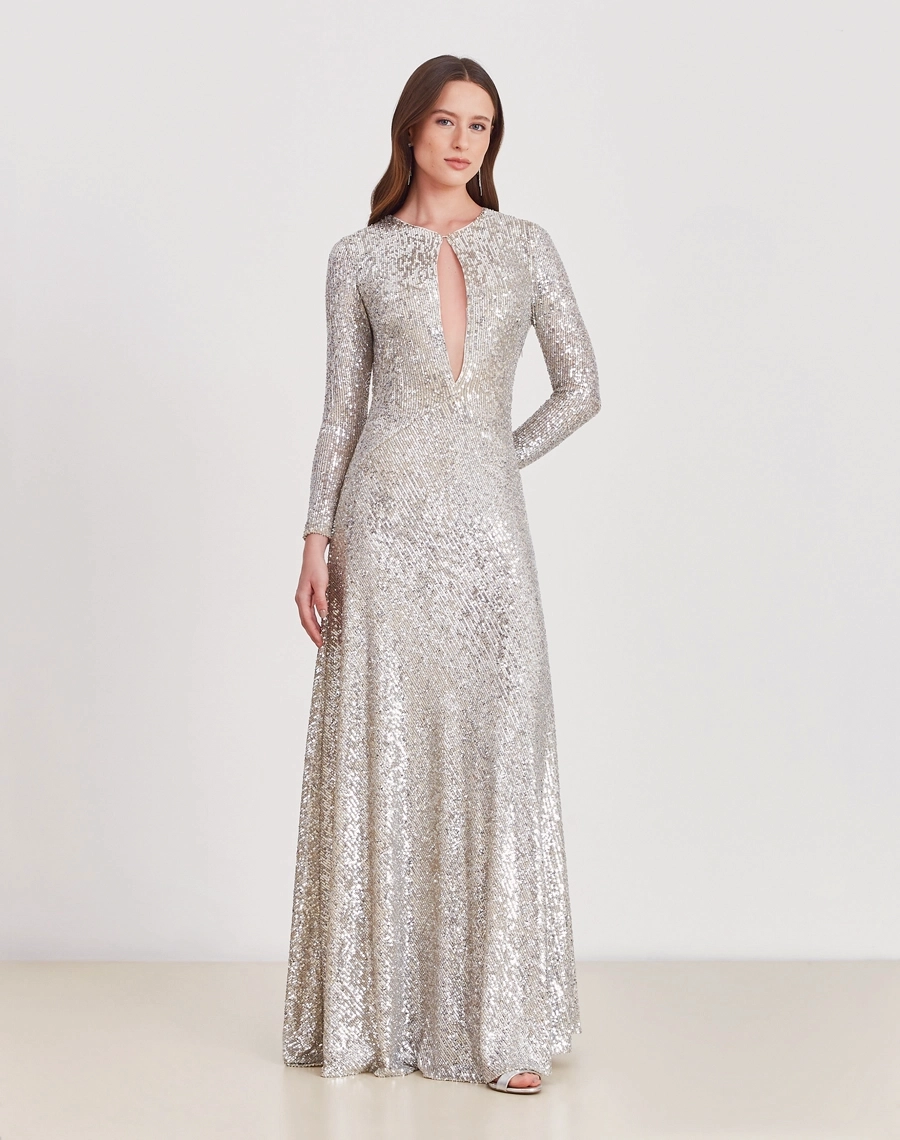 O Vestido Longo Jessie é todo confeccionado em paetê prata, conhecido pelo seu brilho intenso e efeito glamuroso.
