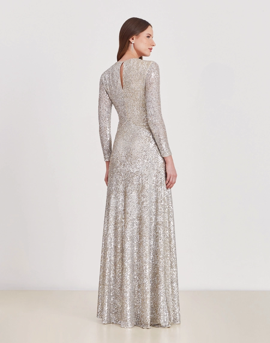 O Vestido Longo Jessie é todo confeccionado em paetê prata, conhecido pelo seu brilho intenso e efeito glamuroso.