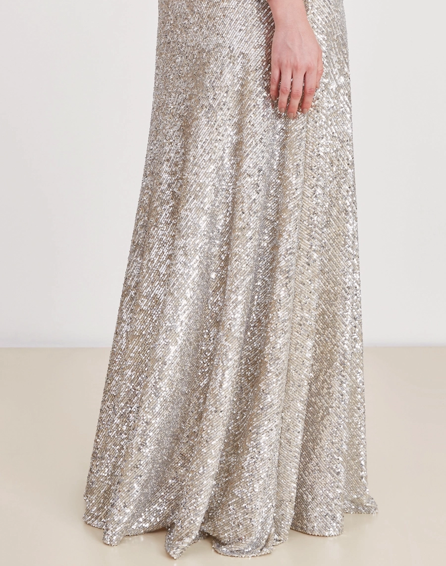 O Vestido Longo Jessie é todo confeccionado em paetê prata, conhecido pelo seu brilho intenso e efeito glamuroso.