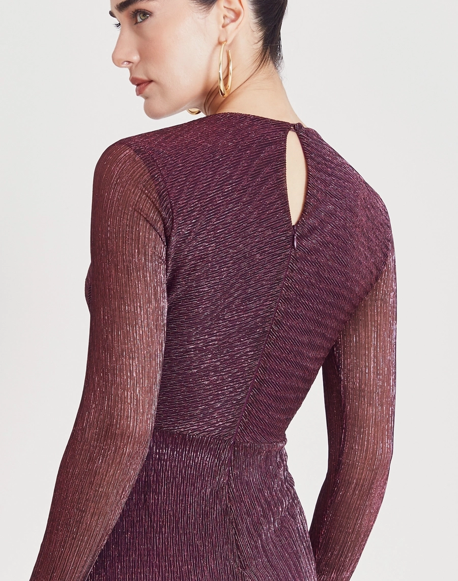 Vestido Midi Erica confeccionado em malha plissada metálica, tecido leve e confortável, caracterizado por sua textura elegante e cheia de movimento.