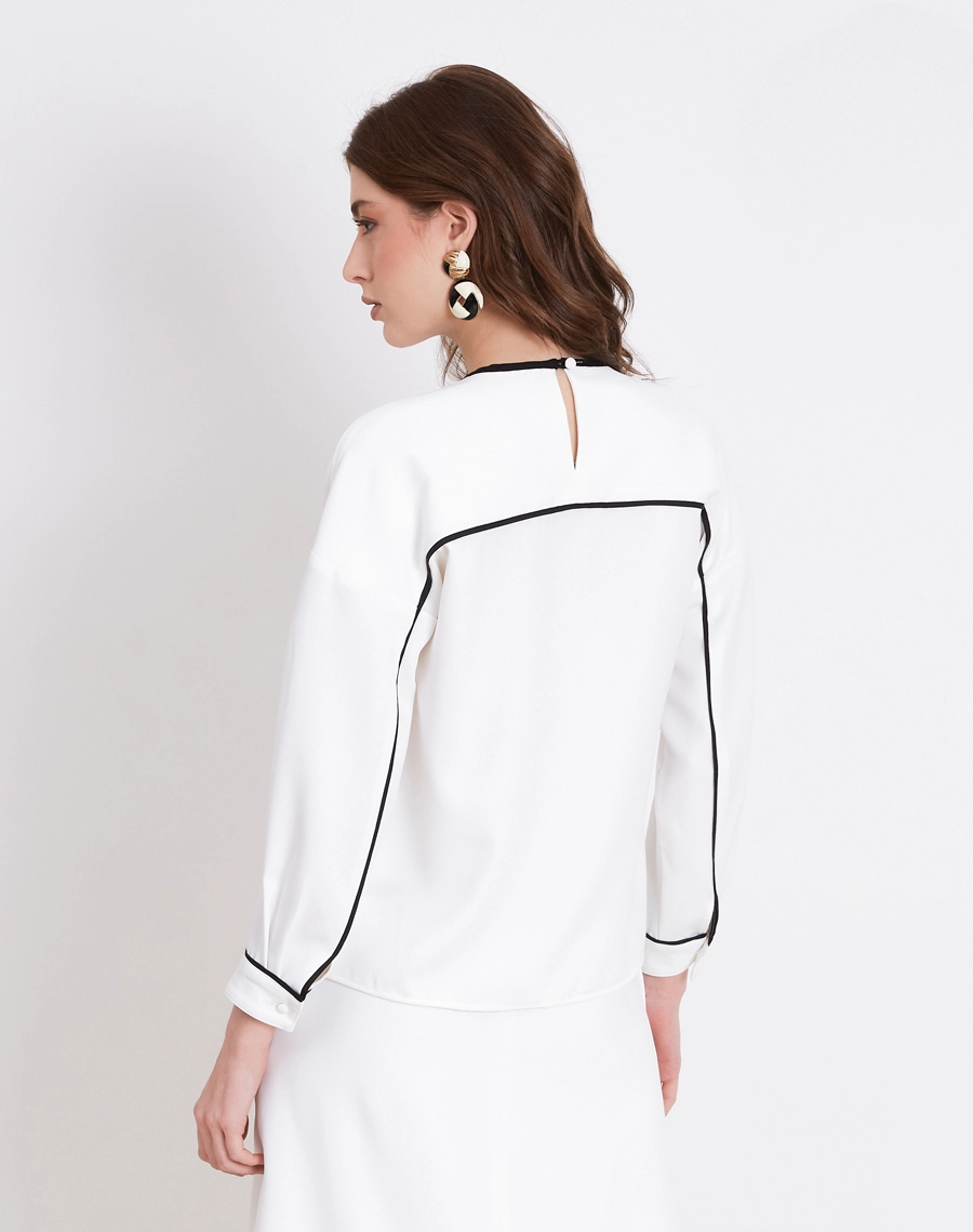 A Blusa Melissa é confeccionada em Crepe Zara, tecido de toque suave e acabamento levemente texturizado, com caimento fluido que não marca o corpo. 