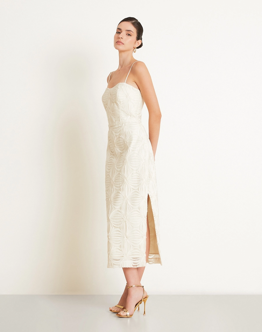 O Vestido Midi Palmo é confeccionado em Tule bordado, um tecido leve e delicado, com transparência sutil e desenhos em relevo que enriquecem a peça com um visual sofisticado e feminino.