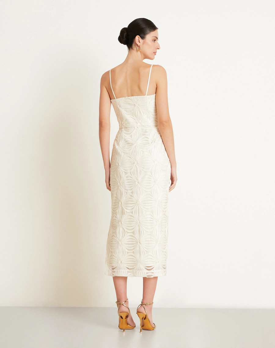 O Vestido Midi Palmo é confeccionado em Tule bordado, um tecido leve e delicado, com transparência sutil e desenhos em relevo que enriquecem a peça com um visual sofisticado e feminino.