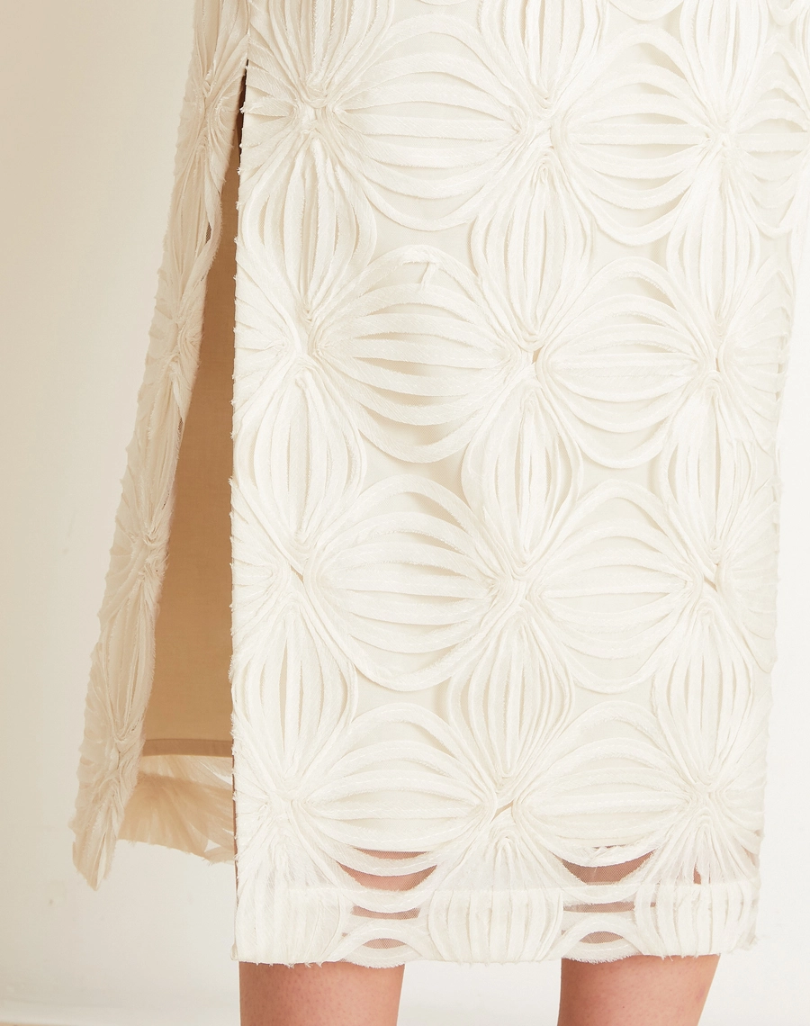 O Vestido Midi Palmo é confeccionado em Tule bordado, um tecido leve e delicado, com transparência sutil e desenhos em relevo que enriquecem a peça com um visual sofisticado e feminino.