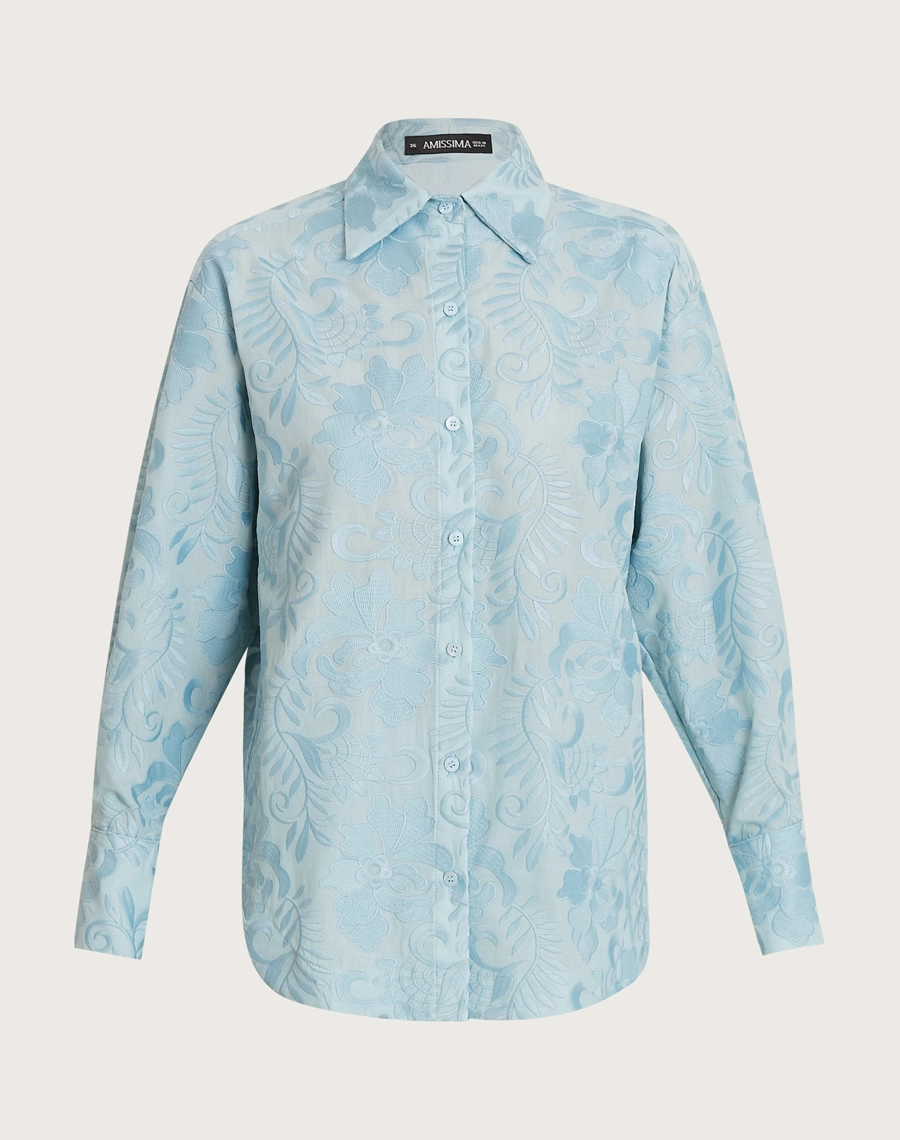 A Camisa Arabela é confeccionada em algodão bordado, com textura delicada e padronagem floral que traz charme ao visual.