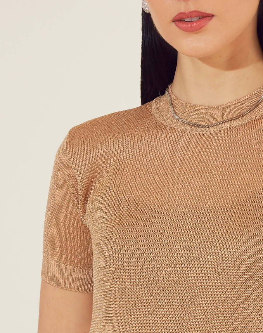 Blusa Charlote é o item perfeito para quem busca sofisticação com um toque moderno e glamouroso.<br/>
Confeccionada em rayon com fios de lurex dourado, essa peça traz um brilho sutil e elegante, ideal para iluminar qualquer look. <br/>
Com mangas curtas e um caimento leve, ela é confortável e versátil, podendo ser combinada com saias, calças ou até jeans para um visual mais casual. <br/>
O acabamento metalizado confere um ar festivo, perfeito para eventos noturnos ou ocasiões especiais que pedem um toque de brilho. <br/>